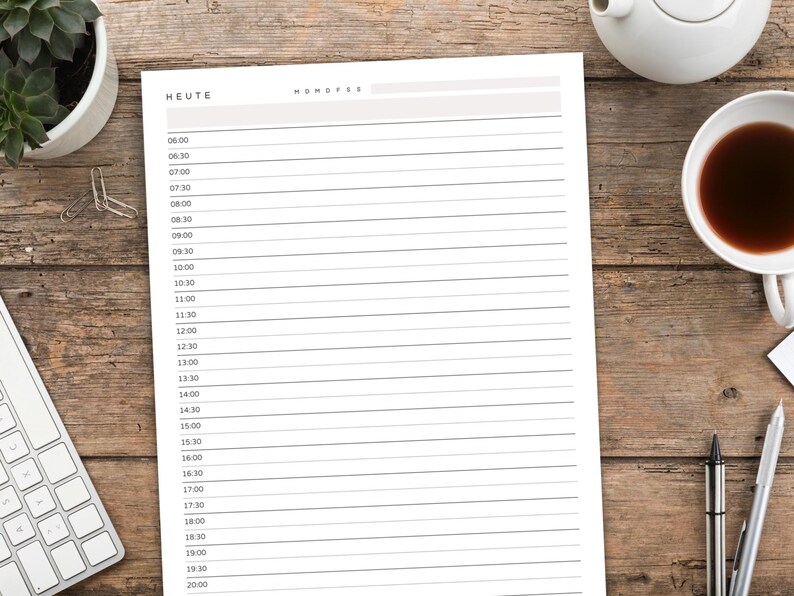 May include: A daily planner sheet with the word "HEUTE" at the top, featuring time slots from 6:00 to 20:00. The planner is on a wooden surface, alongside a cup of tea, a teapot, a pen, and a keyboard.