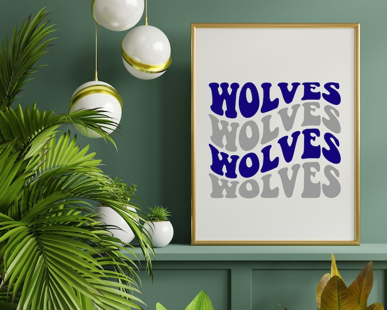 May include: A framed print with the word "WOLVES" in blue and grey, repeated in a wavy design. The gold-framed artwork is displayed on a green shelf, with green plants in the foreground.