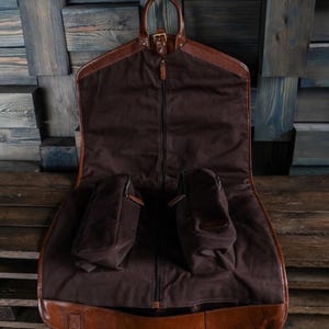 Personalized leather suit carrier, perfect for men. A durable hanging garment bag for travel, ideal for suits, groomsmen gifts, and special occasions like Christmas.