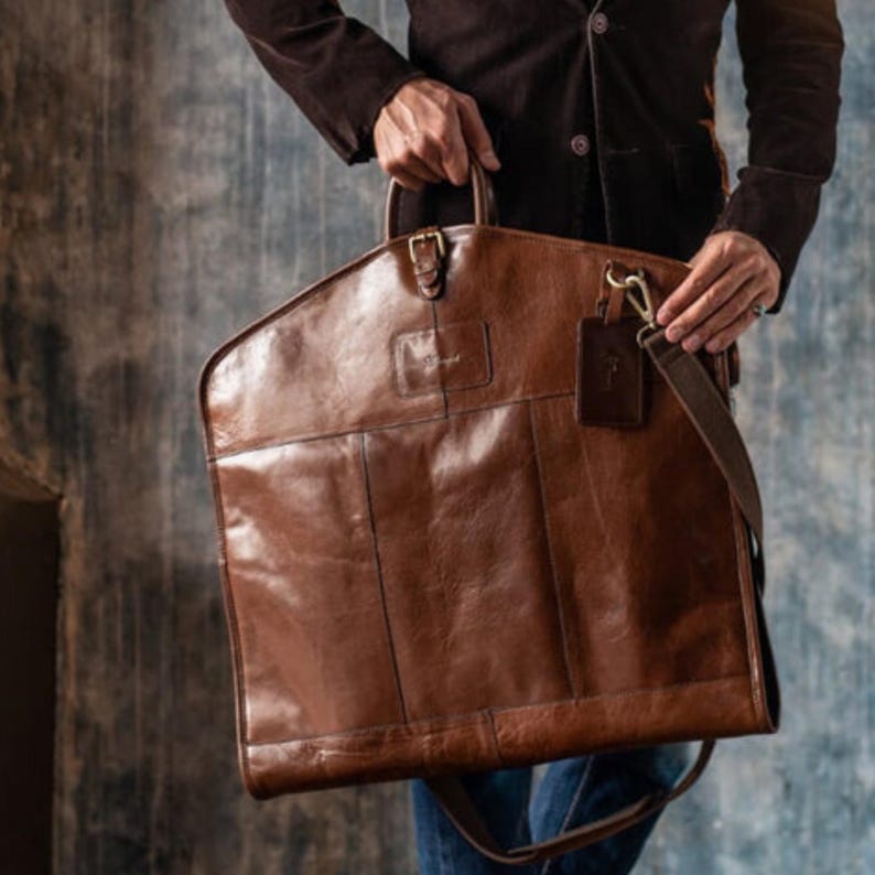 Premium leather suit carrier, handmade and durable. Ideal as a travel garment bag for men, perfect for suits and groomsmen gifts, combining style and function effortlessly.