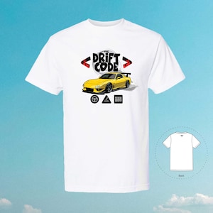 Pode incluir: Camiseta branca com uma ilustração de um carro amarelo e o texto "The Drift Code" em preto. O carro está rodeado de chamas vermelhas e fumaça. A camiseta também apresenta um círculo, um triângulo e um quadrado pretos.