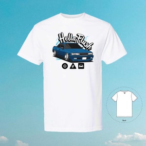 May include: White t-shirt featuring a blue car illustration and the text "Hella Flush" in a stylised font. The car has a black front bumper and black wheels. There are three icons below the car: a tyre, a triangle, and a car.