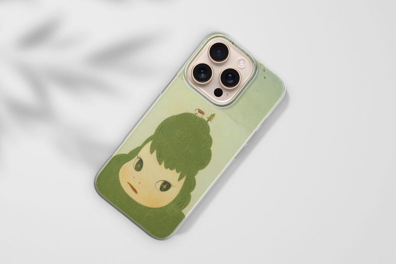 Op de afbeelding: Telefoonhoesje met een grillige illustratie van een meisje met groen haar en een klein huisje op haar hoofd. De hoes heeft een lichtgroene achtergrond en een transparante rand, met de camera van de telefoon zichtbaar.