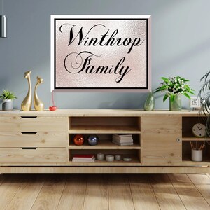 Pode incluir: Um arm&aacute;rio de madeira com gavetas e prateleiras abertas, adornado com objetos decorativos e plantas. Uma placa emoldurada com as palavras "Winthrop Family" est&aacute; pendurada acima. O quarto &eacute; decorado com uma est&eacute;tica moderna.