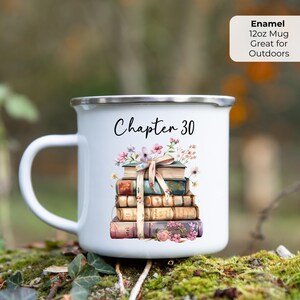 May include: White enamel mug with a silver rim and a large handle. The mug features a stack of books with floral accents and the text "Chapter 30." The mug is 12oz and suitable for outdoor use.