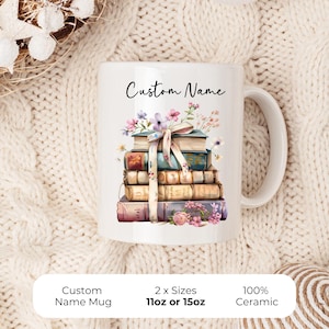 May include: White ceramic mug with a design of stacked books, flowers, and a ribbon. The words "Custom Name" are printed on the mug. Available in 11oz or 15oz sizes.