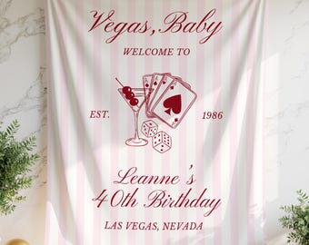 May include: A fabric wall hanging featuring a light pink and white vertical striped pattern. The design includes dark red text reading Vegas, Baby, WELCOME TO, EST. 1986, Leanne's 40th Birthday, and LAS VEGAS, NEVADA, with illustrations of playing cards, dice, and a martini glass.