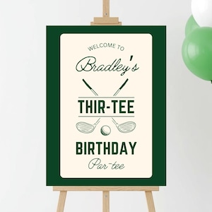 May include: A green and cream-colored sign on a wooden easel. The sign reads "Welcome to Bradley's Thir-tee Birthday Par-tee" with golf-themed graphics. Green and white balloons are in the background.