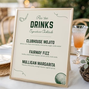 May include: A gold-coloured framed sign displaying a drinks menu for a golf-themed event. The sign lists cocktails such as a Clubhouse Mojito and Fairway Fizz. The sign includes golf-themed graphics.