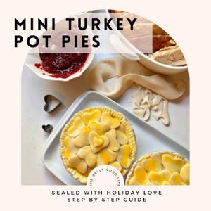 Może przedstawiać: Dwa mini paszteciki z indykiem z dekoracjami w kształcie serca na białej tacy. Obraz zawiera tekst "MINI TURKEY POT PIES" i "SEALED WITH HOLIDAY LOVE STEP BY STEP GUIDE". Widoczne są również wykrawacze do ciastek w kształcie serca i miska z sosem żurawinowym.