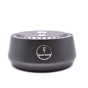 Pode incluir: Um difusor redondo preto com um logotipo branco que diz "Simply Scents".