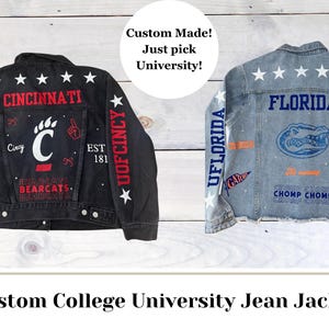 May include: Custom college university jean jackets. One black jacket features "Cincinnati" and "Bearcats" in red, with white stars. The other is a light blue jacket with "Florida" and "Gators" in blue and orange.