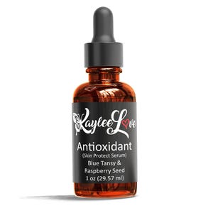 May include: A brown glass bottle with a black dropper top and a black label. The label says "Laylee Love Antioxidant (Skin Protect Serum) Blue Tansy & Raspberry Seed 1 oz (29.57 ml)"