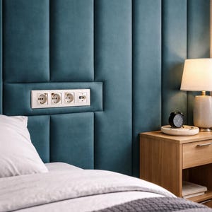 Peut inclure: Tête de lit rembourrée bleu sarcelle avec panneaux verticaux et prise de courant intégrée. Une table de chevet en bois avec une lampe et un réveil. Le lit a un oreiller blanc et une couverture à rayures grises et blanches.
