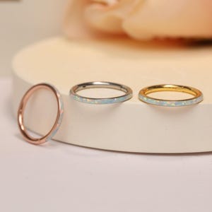 Op de afbeelding: Drie oorringen met een dunne band van opaal-inleg. De oorringen zijn verkrijgbaar in goud, zilver en rosé goud.