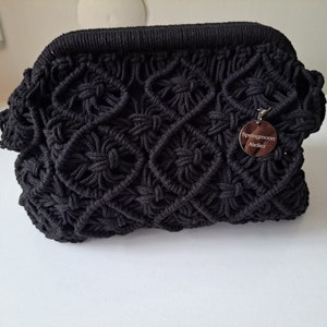 Op de afbeelding: Zwarte gecrochete tas met een zilveren label met de tekst "Springmoon Atelier".