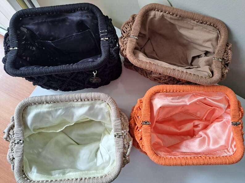Op de afbeelding: Vier gehaakte tassen met verschillende gekleurde voeringen. De tassen zijn allemaal gesloten en hebben een geweven textuur. De kleuren van de voeringen zijn zwart, bruin, beige en oranje.