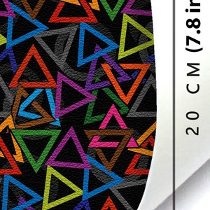 May include: A black fabric with a colourful geometric pattern of overlapping triangles. The fabric is 20 cm (7.8 inches) wide.