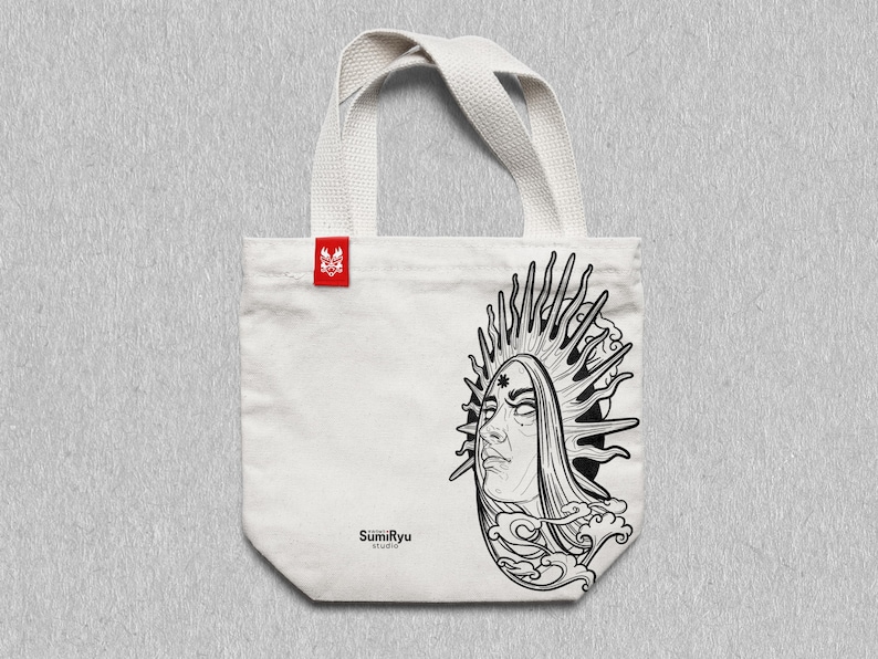 May include: White tote bag with black and white line art of a woman's face with a sunburst behind her. The text "SumiRyu Studio" is printed on the bag.
