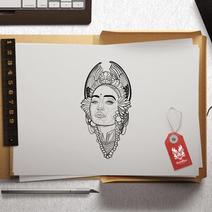 May include: A black and white line drawing of a woman's face with intricate floral designs around her head and neck. The drawing is on a white sheet of paper.