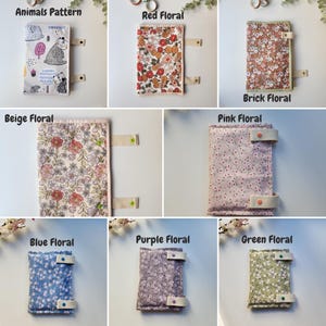 May include: A collection of fabric book covers with various patterns. The covers include an animal pattern, red floral, brick floral, beige floral, pink floral, blue floral, purple floral, and green floral designs. Each cover has a strap closure.