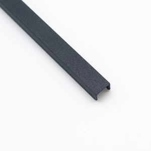 Peut inclure: Une longue bande de canal en forme de U, &eacute;troite, avec une finition mate textur&eacute;e gris fonc&eacute;. L'objet pr&eacute;sente un profil lin&eacute;aire coh&eacute;rent avec des extr&eacute;mit&eacute;s ouvertes, montrant une structure rigide et une texture uniforme sur toute sa longueur.