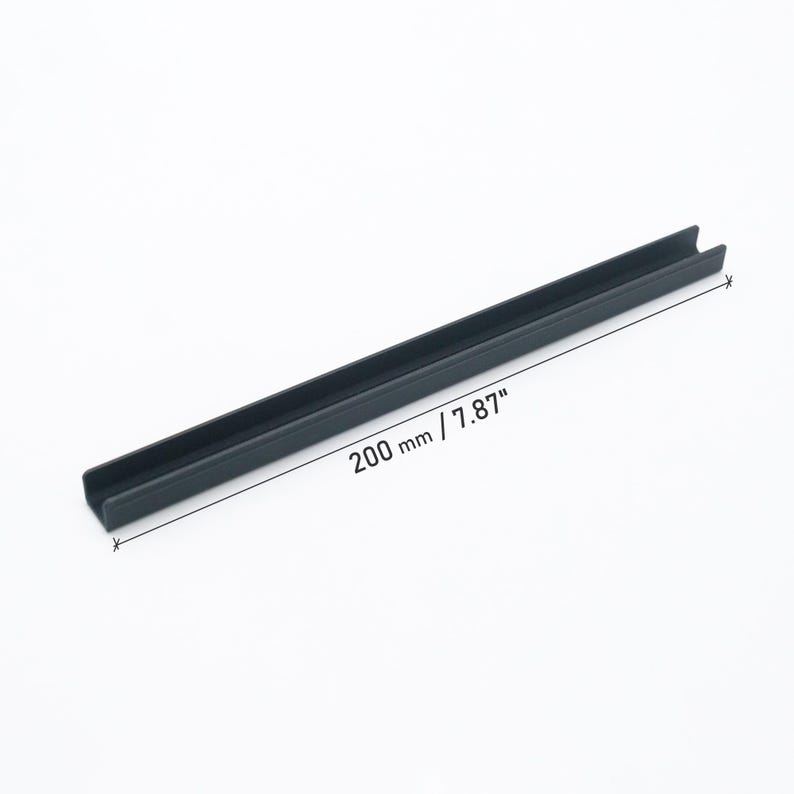 Peut inclure: Un profil&eacute; en U noir mat au design lin&eacute;aire. L'objet pr&eacute;sente un indicateur de mesure clair affichant une longueur de 200 mm, offrant une r&eacute;f&eacute;rence visuelle pr&eacute;cise pour ses dimensions physiques dans un format m&eacute;trique standard.
