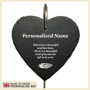 May include: Black slate heart-shaped memorial plaque with a silver ring at the top. The plaque has a white feather design and the text "Personalised Name Wherever a beautiful soul has been. There is a beautiful trail of memories left to be seen."