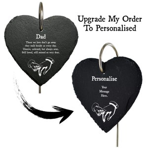 May include: Two black heart-shaped slate garden stones with a silver ring. The first stone has the text "Dad" and a poem about those who have passed. The second stone has the text "Personalise" and the text "Your Message Here".