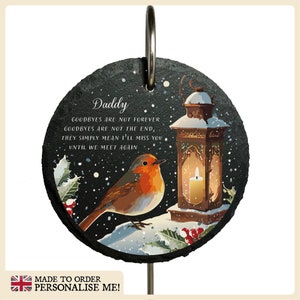 May include: A black slate memorial plaque with a robin, a lantern, and holly. The plaque reads "Daddy, Goodbyes are not forever, Goodbyes are not the end, They simply mean I'll miss you until we meet again."