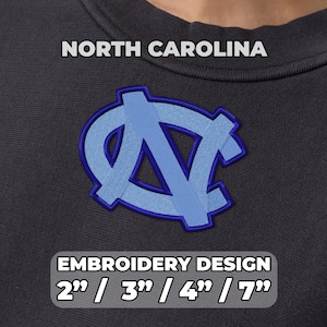 Op de afbeelding: Een donkergrijs sweatshirt met een geborduurd lichtblauw North Carolina-logo met een donkerblauwe omlijning. De tekst NORTH CAROLINA staat boven het logo en EMBROIDERY DESIGN 2" / 3" / 4" / 7" staat onder het logo.