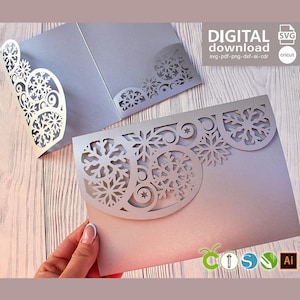 May include: A silver-colored laser-cut card featuring an intricate snowflake and swirl pattern along the top edge. The card is presented as a digital download with file formats including SVG, PDF, PNG, DXF, and AI, suitable for use with Cricut machines.