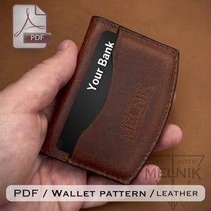 May include: A brown leather card holder wallet featuring visible stitching along the edges and the embossed text MELNIK. A black card with the white text Your Bank is inserted into the front slot. The wallet is held in a hand against a brown background.