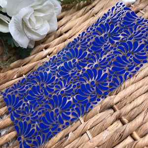 May include: A clear plastic sheet with a blue and white floral pattern. The pattern is made up of small, stylized flowers and leaves.