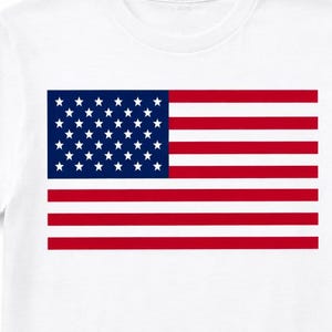 May include: White t-shirt featuring the American flag design. The flag has a blue rectangle with white stars in the upper left corner and red and white stripes. The shirt is a classic crew neck style.