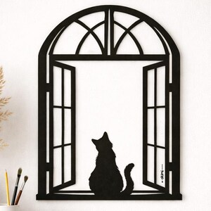 May include: Black metal cat silhouette sitting in an open window frame. The window has an arched top and is open, with the cat's silhouette visible against a white background. The design is suitable for wall decor.