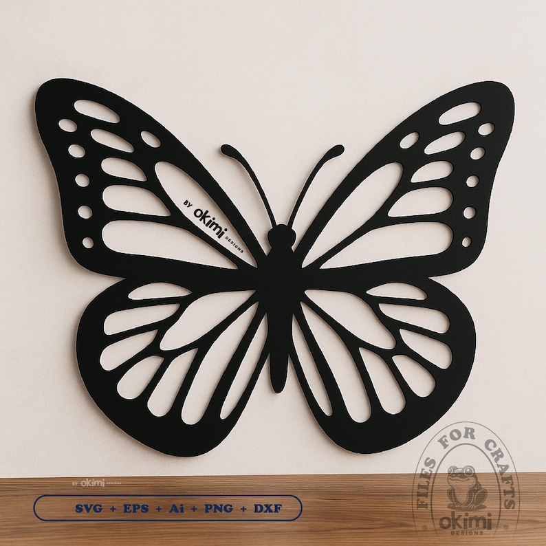 May include: Black silhouette of a butterfly with intricate wing details. The butterfly is centered on a white background. The text "By okimi designs" is visible in the upper center of the image.