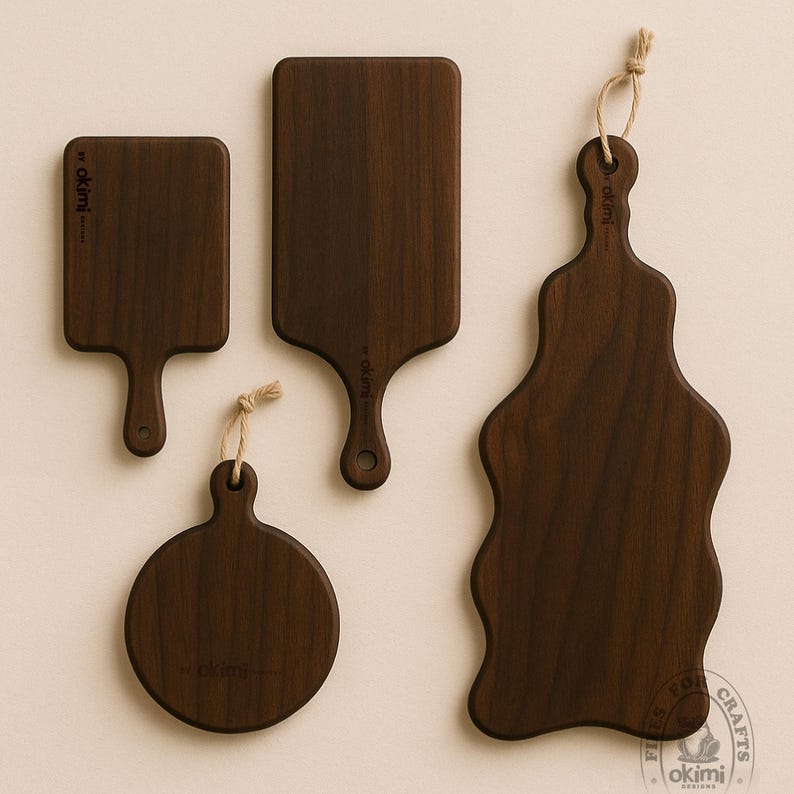 Puede incluir: Cuatro tablas de cortar de madera marr&oacute;n oscuro de varias formas. Dos tablas rectangulares con asas, una tabla redonda y una tabla de forma &uacute;nica. Cada tabla tiene una veta de madera natural y un peque&ntilde;o lazo para colgar. Las tablas est&aacute;n etiquetadas con "by okimi".