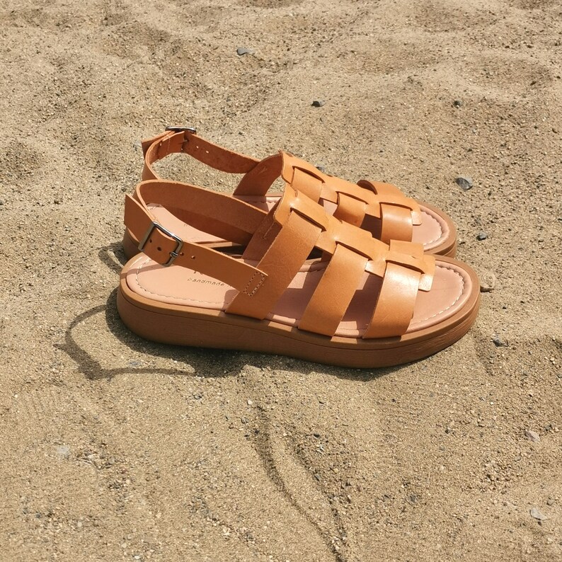 May include: Tan leather sandals with a woven design and a thick platform sole. The sandals have a buckle closure and the brand name "Samara" is visible on the sole.