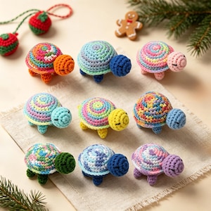 May include: A collection of nine small, handmade crochet turtles arranged in a grid. Each turtle features a multi-colored, spiraled shell and a solid-colored head and limbs. The yarn colors include shades of blue, pink, yellow, green, and orange.