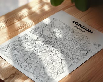 May include: A black and white map of London, United Kingdom, printed on a white rectangular paper. The map shows the city's streets and landmarks in detail. The word "LONDON" is printed in bold black letters at the top right corner.