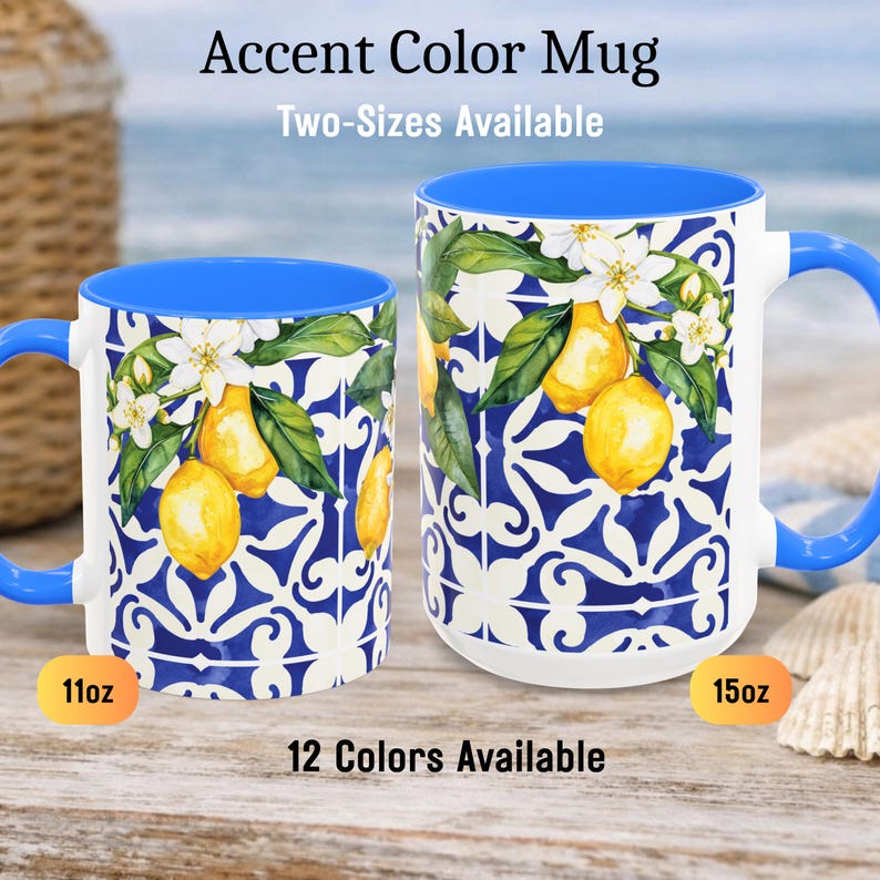 May include: Two white ceramic accent color mugs with blue handles and interiors. The mugs feature a lemon and floral design on a blue and white patterned background. The text "Accent Color Mug" and "Two-Sizes Available" are displayed.