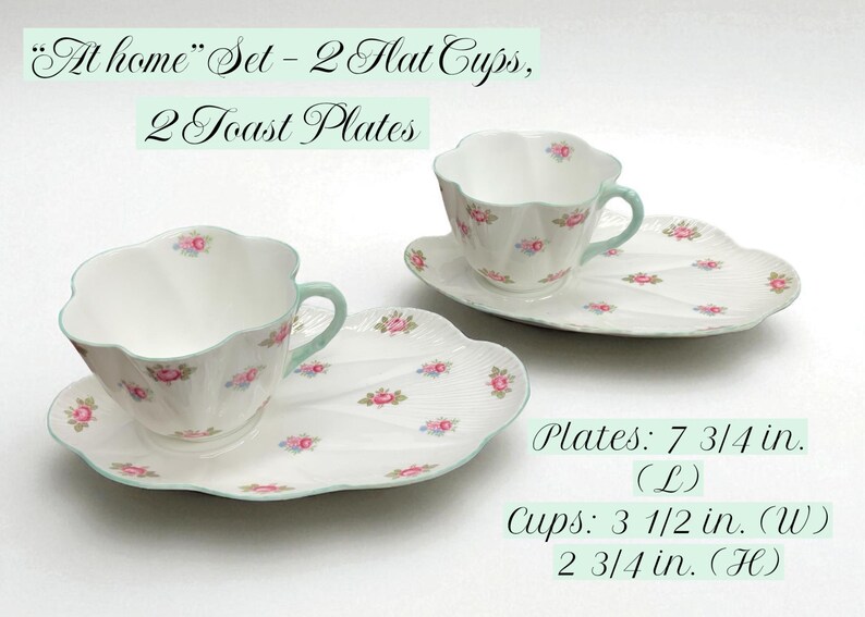 May include: A floral-patterned teacup and saucer set. The set includes two cups and two plates. The plates are 7.75 inches long, and the cups are 3.5 inches wide and 2.75 inches high. The set is decorated with pink roses and a mint green trim.