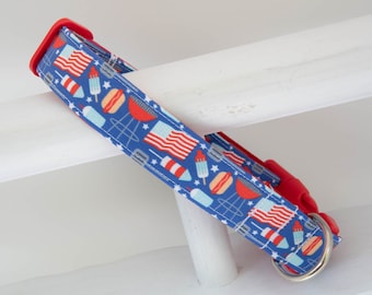 Puede incluir: Un collar de perro rojo y azul con un tema festivo del 4 de julio. El collar presenta un patrón de banderas americanas, fuegos artificiales, conos de helado y perritos calientes sobre un fondo azul.