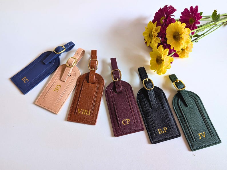 Custom intitial luggage tags fanned out in blue, blush, brown, burgundy, black and green.