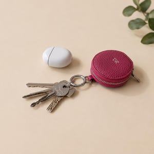 Pink leather zip wallet keychain with the initals DR attached to a set of keys.