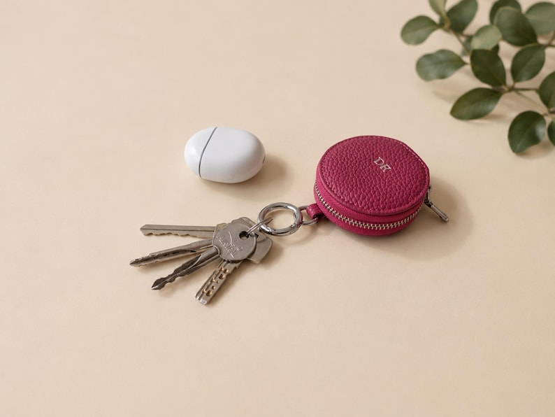 Pink leather zip wallet keychain with the initals DR attached to a set of keys.