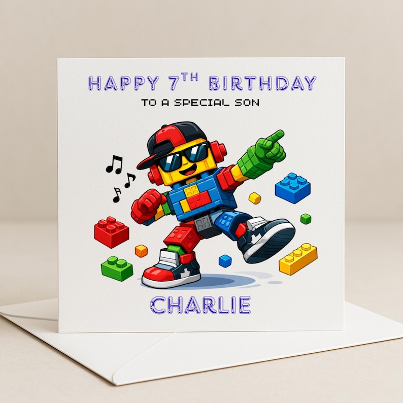 May include: A birthday card with a cartoon robot made of building blocks, wearing sunglasses and a cap. The card reads "Happy 7th Birthday to a Special Son" and is personalised with the name "Charlie". Musical notes and building blocks are scattered around the robot.