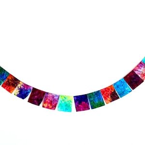 May include: A decorative banner consisting of a string of rectangular fabric flags featuring a vibrant tie-dye pattern. The flags display a spectrum of colors including deep purple, bright blue, emerald green, warm orange, and magenta.