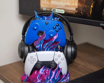 Suporte duplo para fone de ouvido e controle com design de caveira e chamas, ideal para jogos.